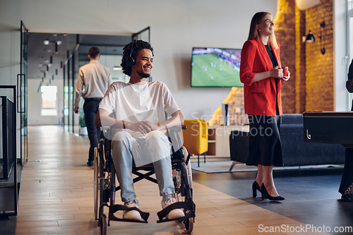 Image of A businessman in a wheelchair occupies a hallway within a modern startup coworking center, embodying inclusivity and determination in the business environment