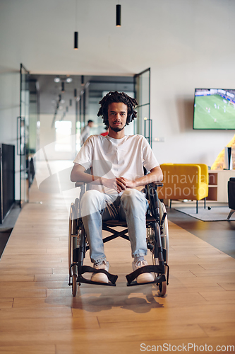 Image of A businessman in a wheelchair occupies a hallway within a modern startup coworking center, embodying inclusivity and determination in the business environment
