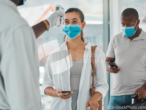 Image of Compliance, travel and covid restrictions by security scanning tourist temperature with a infrared thermometer at airport. Worker checking or fever for other corona related symptoms at work