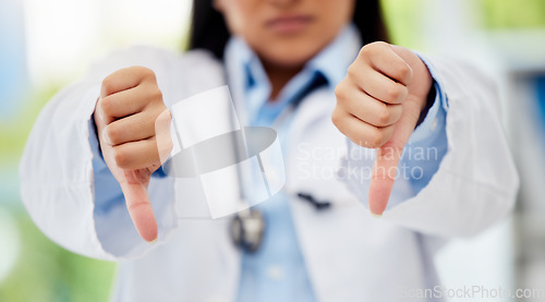 Image of Doctor with thumbs down hand sign in healthcare hospital or lab for fail, poor health insurance or death statistics. Zoom of unhappy, bad loss or loser hands emoji icon of a healthcare professional