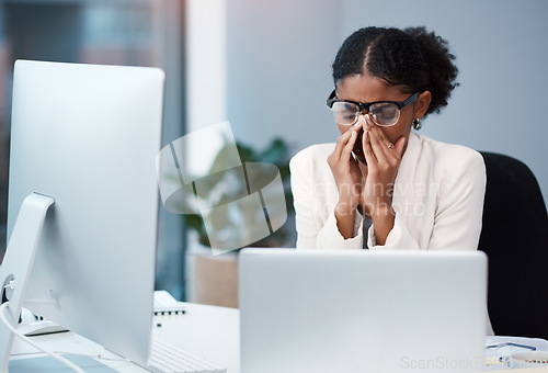 Image of Sad unhappy business woman with headache, migraine or burnout working on a computer in an office alone at work. One tired, anxious and frustrated corporate female boss looking exhausted and upset