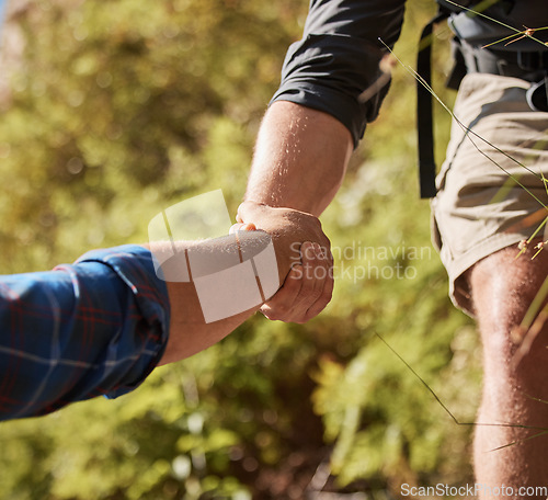 Image of Support, teamwork and helping hands by hikers hiking outdoors in nature on a mountain trail. Fit and active friends help each other closeup and while trekking and climbing tough terrain