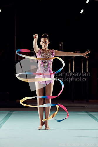 Image of Ribbon dancer, woman and stage performance or practice at gym. Girl with flexibility does physical and artistic sports training. Balance, strong and gymnastic body of young athlete with discipline.