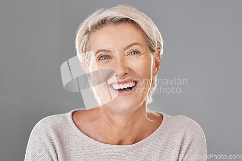 Image of Grooming, skincare and face of happy mature woman laughing against a studio grey background. Senior female feeling fresh, enjoying free time with self care hygiene treatment. Joy after routine pamper