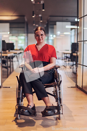 Image of A modern young businesswoman in a wheelchair is surrounded by an inclusive workspace with glass-walled offices, embodying determination and innovation in the business world