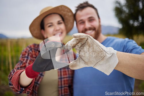 Image of Farmer or gardener couple showing love heart sign with their hands outdoors on an organic or sustainable farm. Happy and excited activists support sustainability or organic farming