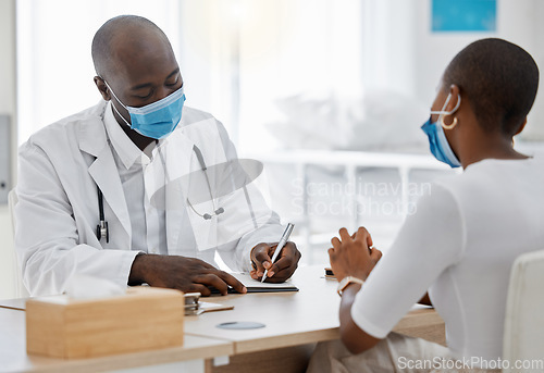 Image of Doctor, office and writing a covid note or medical history, record or insurance paperwork for patient at work. Black healthcare professional man or GP signing documents for client with masks.