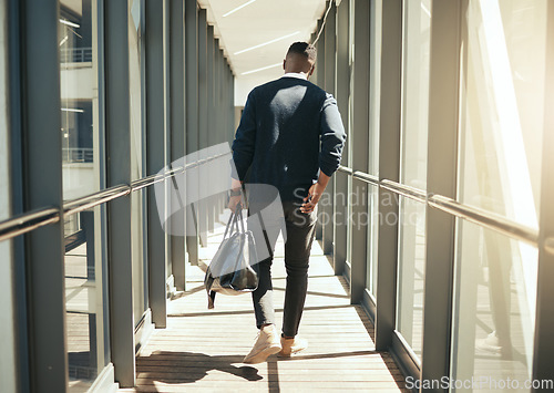 Image of Businessman at airport walking for work travel and male african morning commute to city. Transport service from airplane terminal to hotel, rear view of modern worker carrying hand luggage bag trip.