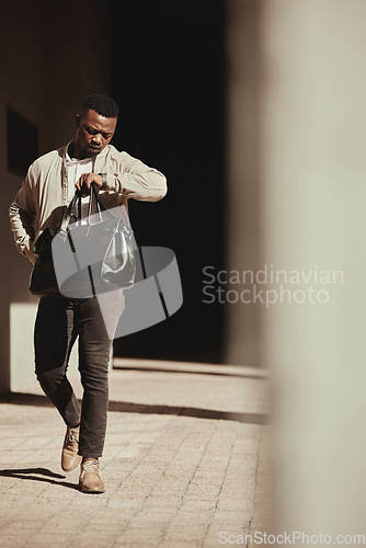 Image of A watch, time and a business man late to a deal or meeting with a bag in the city. Busy black male worker, walking or travel or journey or rushing to a bus or plane for corporate business trip