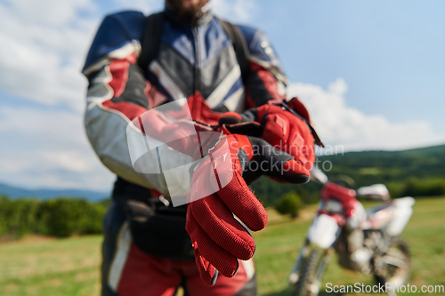 Image of A professional motocross rider putting his gloves and preparing for a professional motocross ride