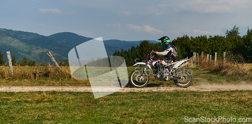 Image of A professional motocross rider exhilaratingly riding a treacherous off-road forest trail on their motorcycle.