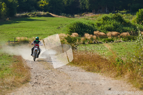 Image of A professional motocross rider exhilaratingly riding a treacherous off-road forest trail on their motorcycle.