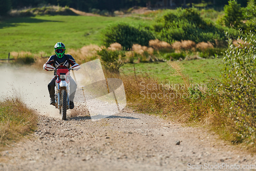 Image of A professional motocross rider exhilaratingly riding a treacherous off-road forest trail on their motorcycle.