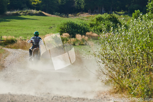 Image of A professional motocross rider exhilaratingly riding a treacherous off-road forest trail on their motorcycle.