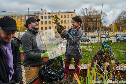 Image of A modern family parents and children, is working together to beautify their front yard with flowers in preparation for the upcoming holiday season.