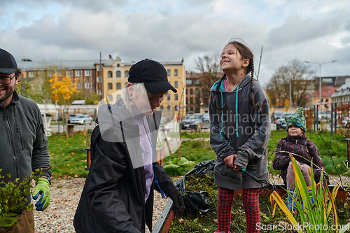 Image of A modern family parents and children, is working together to beautify their front yard with flowers in preparation for the upcoming holiday season.