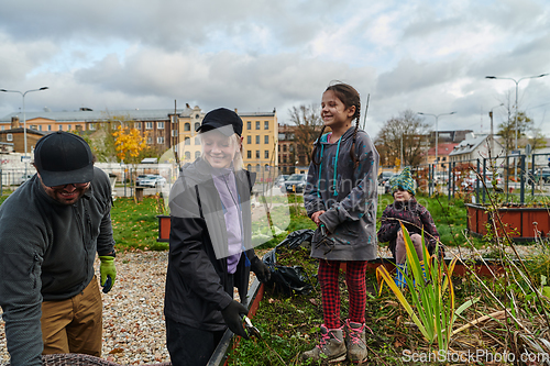 Image of A modern family parents and children, is working together to beautify their front yard with flowers in preparation for the upcoming holiday season.