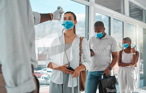 Image of Covid safety traveling, medical doctor with thermometer testing and screening or healthcare doing protocol checkup of people at airport. Travel nurse worker scanning during the corona virus pandemic