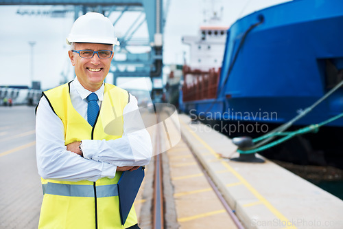 Image of Industrial worker working on a shipping port to export stock, containers and packages. Portrait of logistics, business and industry employee with a crane at a cargo freight warehouse dock.