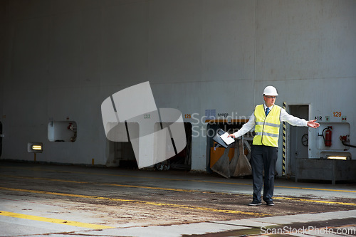 Image of Logistics worker, manager or engineer, working in a shipping yard or cargo dock. Port employee, giving direction to load container for safety, storage or export. Industrial management and planning.