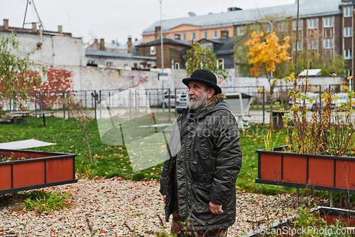 Image of In the historic city of Riga, a bearded elderly man passionately explains the traditional symbolism of Halloween, connecting generations through cultural heritage and folklore.