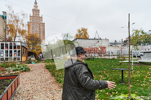 Image of In the historic city of Riga, a bearded elderly man passionately explains the traditional symbolism of Halloween, connecting generations through cultural heritage and folklore.