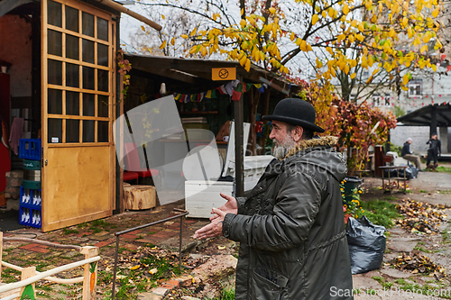 Image of In the historic city of Riga, a bearded elderly man passionately explains the traditional symbolism of Halloween, connecting generations through cultural heritage and folklore.