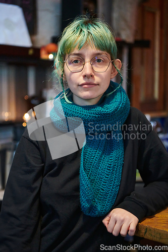 Image of A modern and intriguing girl with striking blue hair enjoys a night out in a cafe transformed into a passionate Halloween-style setting, exuding a captivating and witchy ambiance