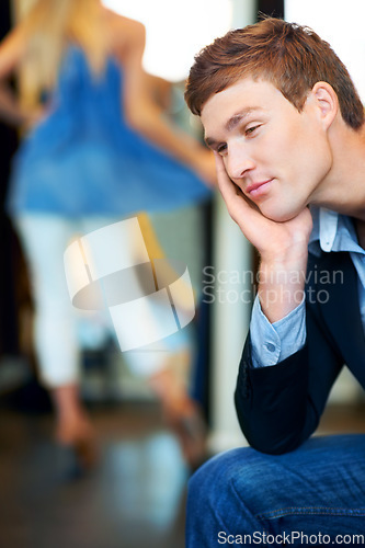 Image of Fashion, retail and store with a tired man waiting for a woman while shopping in a clothing boutique. Patient person almost sleeping in a retail store while female consumer is spending money and cash