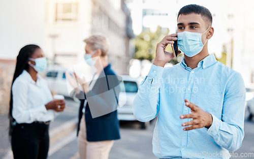 Image of Covid, medical mask and phone call businessman talking on 5g network, mobile or smartphone outside with team in background. Communication, teamwork and collaboration with worker on cellphone.