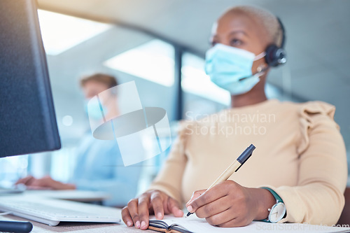 Image of Writing, documents and covid of a woman with a mask while at work in customer support in a call center. Female contact agent in telemarketing helping client and taking notes on a desk at the office.