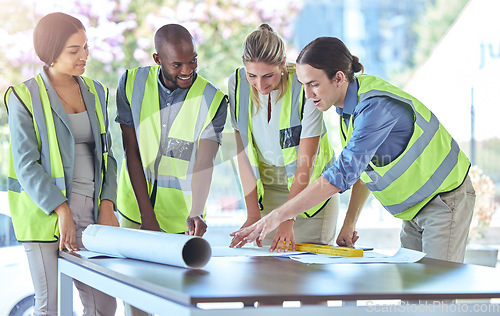 Image of Industrial engineer team planning with blueprint paperwork in a meeting in an office or boardroom. Architect group of people collaborate on a building project working together on the design