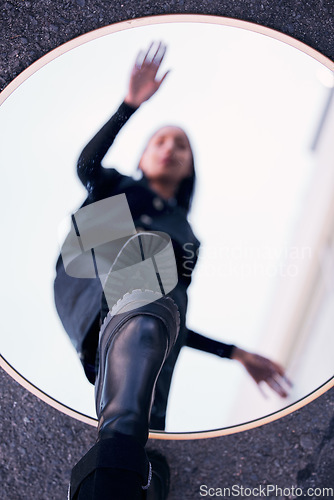 Image of Mirror, reflection and fashion shoes of a woman standing on a blur vision of herself in the street outdoors. Female person on glass with shoe in reflect for self awareness in edgy, cool and style.