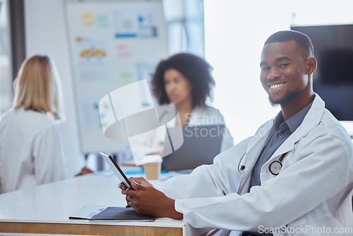 Image of Healthcare, medicine and a doctor on a tablet in a hospital boardroom or office after meeting or presentation. Happy medical worker with a smile, online at a table. Doctors on a coffee break at work.