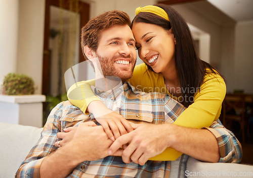 Image of Diversity, love and happy couple in living room sofa together, sharing intimate moment at home. Freedom, smile and relax young married man embracing woman bonding on marriage anniversary