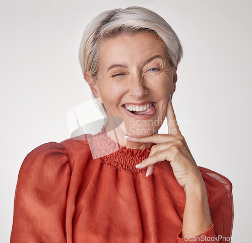 Image of Comic portrait, quirky model or playful mature woman on gray studio background with funny facial expression, tongue or happy wink face. Silly, classy fashion and elegant stylish beauty or cool person