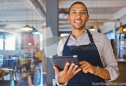 Image of Restaurant entrepreneur with tablet, leaning on door and open to customers portrait. Owner, manager or employee of a startup fast food store, cafe or coffee shop business standing happy with a smile