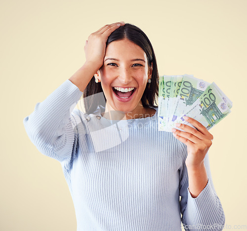 Image of Woman celebrating success, winning money or lottery victory, holding cash or banknotes in hand. Portrait of excited, happy and proud winner screaming and laughing, with yellow copyspace background.