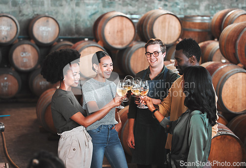 Image of Friends, wine tasting or toasting alcohol with drink glasses in local farm distillery, winery estate or countryside room. Diversity, bonding or happy celebration people together with vineyard barrels