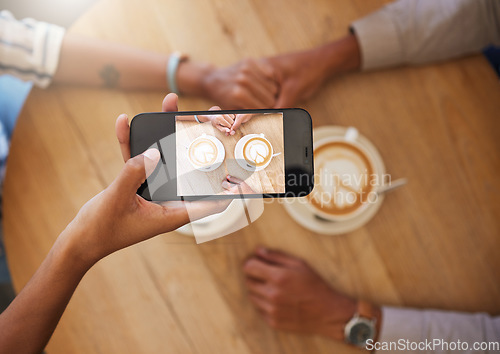 Image of Phone influencer couple at a coffee shop taking photo of coffee on a romantic date for social media vlog. Top view POV of trendy people in love sharing anniversary or valentines day memories online