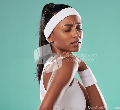 Image of Sports injury, shoulder pain and tennis player suffering with sore muscles after a game while standing against a studio background. Painful, hurt and discomfort after training or playing in a match