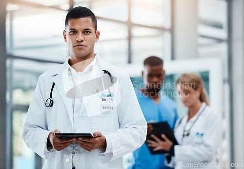 Image of Doctor or surgeon working with electronic documents on digital tablet, standing in hospital hallway or foyer. Healthcare professional doing virtual consultation online or using medical software app.