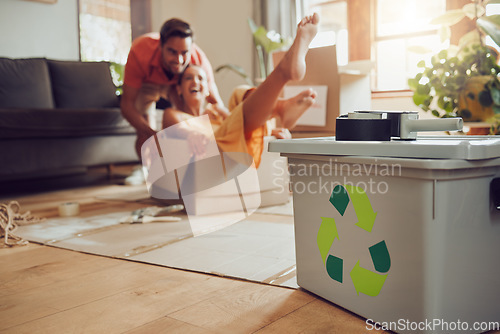 Image of Fun couple moving into new house, playing with boxes and being playful after relocation to apartment together. Carefree man and woman recycling at home, living sustainable and reducing waste