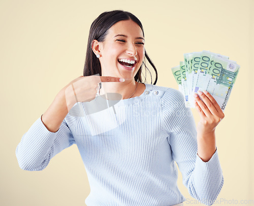 Image of . Money, investment growth and finance success of a happy, excited and smiling woman pointing at cash reward. Lucky and happy female showing her growing financial wealth, savings or bank loan payout.