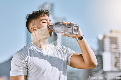 Image of Fitness, healthy thirsty man drinking water while he is exercising outside in sportswear. Runner, cardio workout and active lifestyle for strong athletic body or mental discipline.