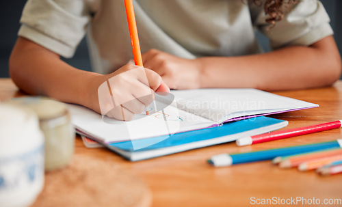 Image of Child coloring, drawing and doing art activity in book in home living room while having fun, enjoying and feeling playful. Closeup hands of small, little and young creative girl expressing with color