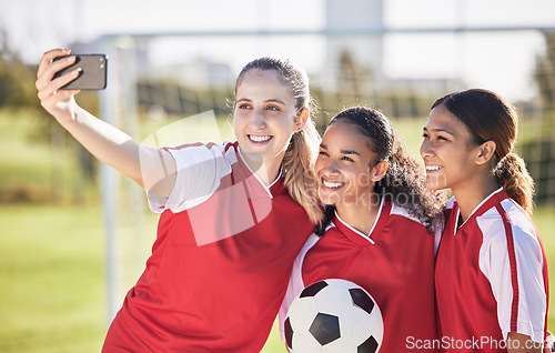 Image of Selfie, soccer and sports team smiling and feeling happy while posing for a social media picture. Diverse and young girls standing together on a football field. Friends and teammates enjoying a match