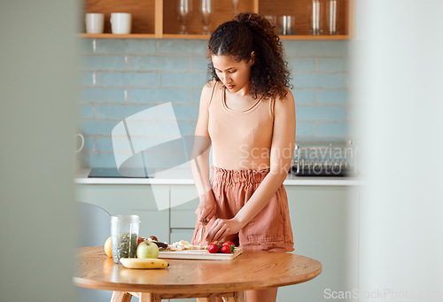 Image of Health, meal and healthy woman alone preparing a nutritional breakfast for herself in the kitchen. Female cutting fruit to make a smoothie or salad with nutrition for an organic lifestyle at home.