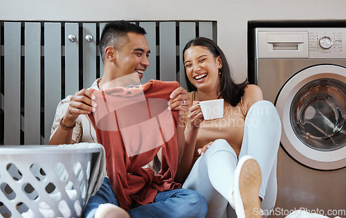 Image of Carefree and funny couple doing laundry and relaxing together at home in the morning. Silly, goofy and playful lovers laughing and giggling while cleaning the washing, and doing house chores