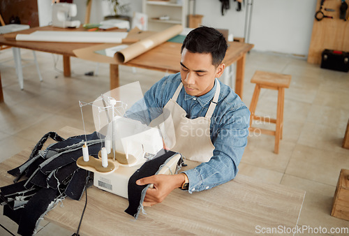 Image of Creative fashion designer or seamstress tailor working on sewing trendy and stylish clothing garment in design studio workshop. Young male dressmaker working on fabric material with machine stitch